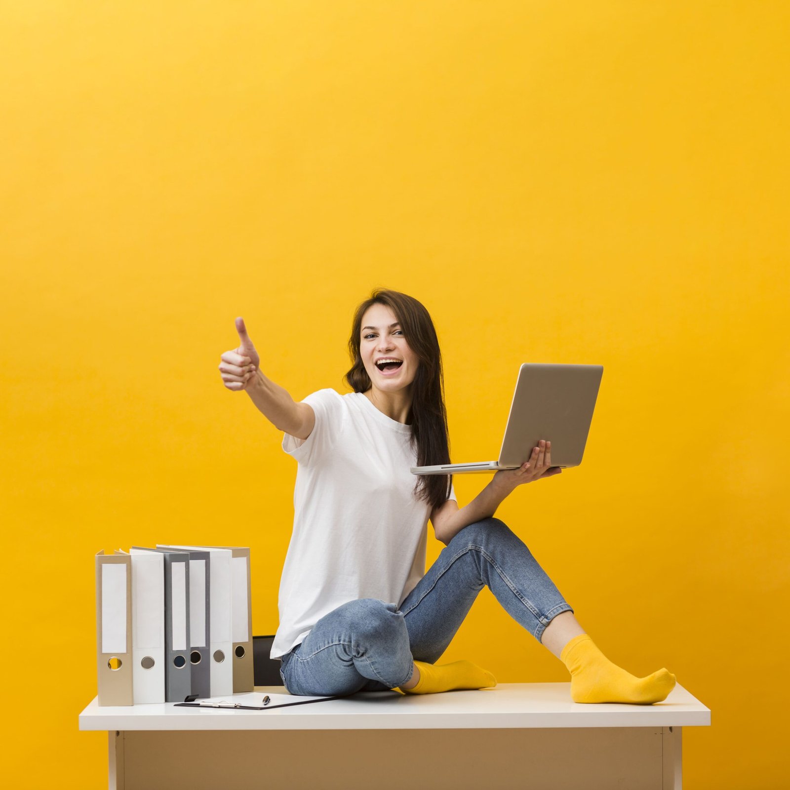 side view smiley woman sitting desk giving thumbs up while holding laptop 1 scaled